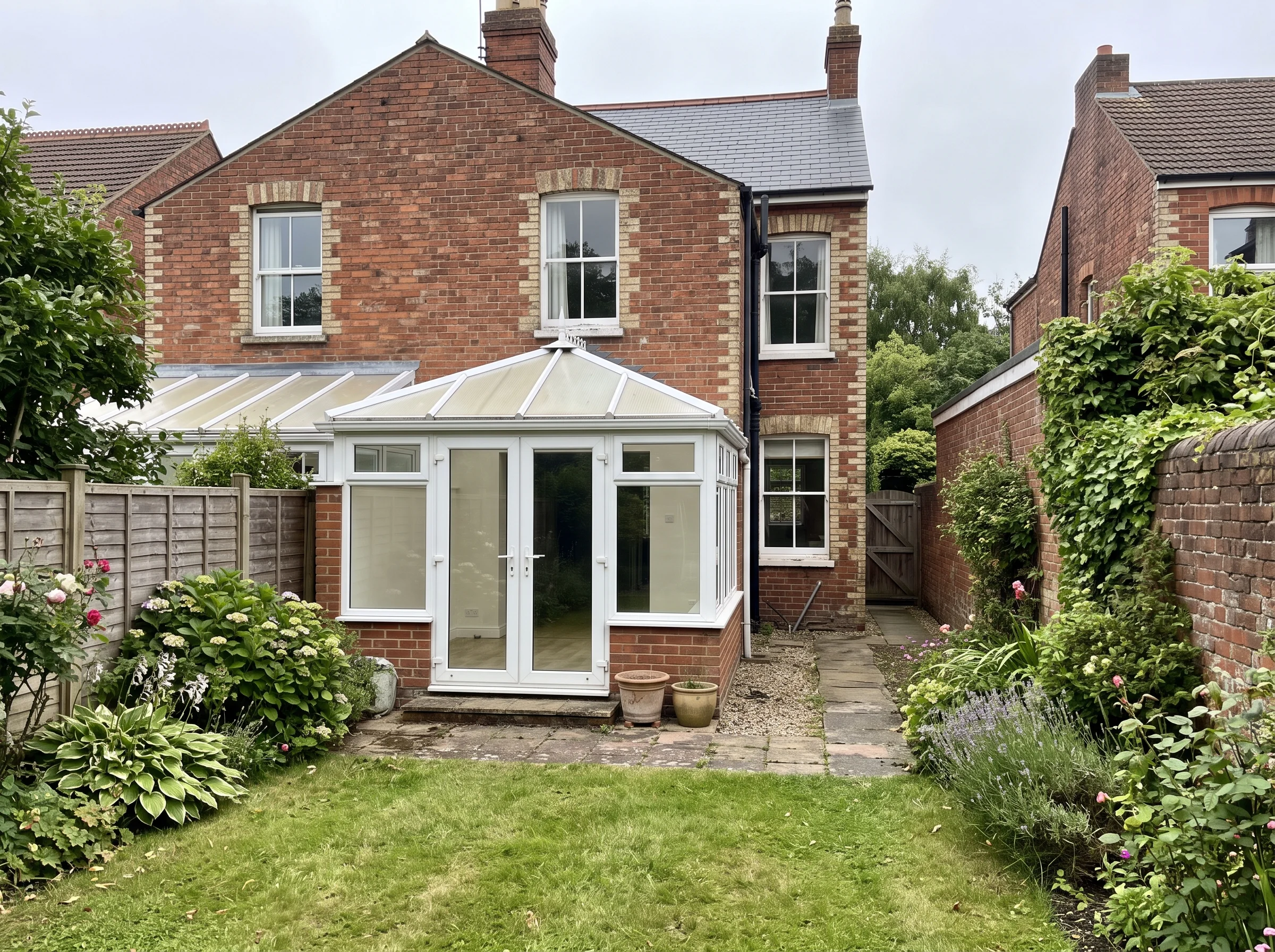 Before: the back of the semi with a uPVC conservatory, a separate kitchen door and a concrete side passage