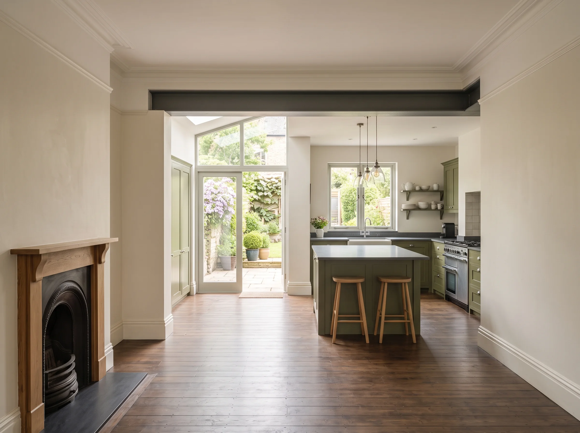 After: the same middle room opened into a daylit kitchen under a long rooflight, with the garden visible beyond